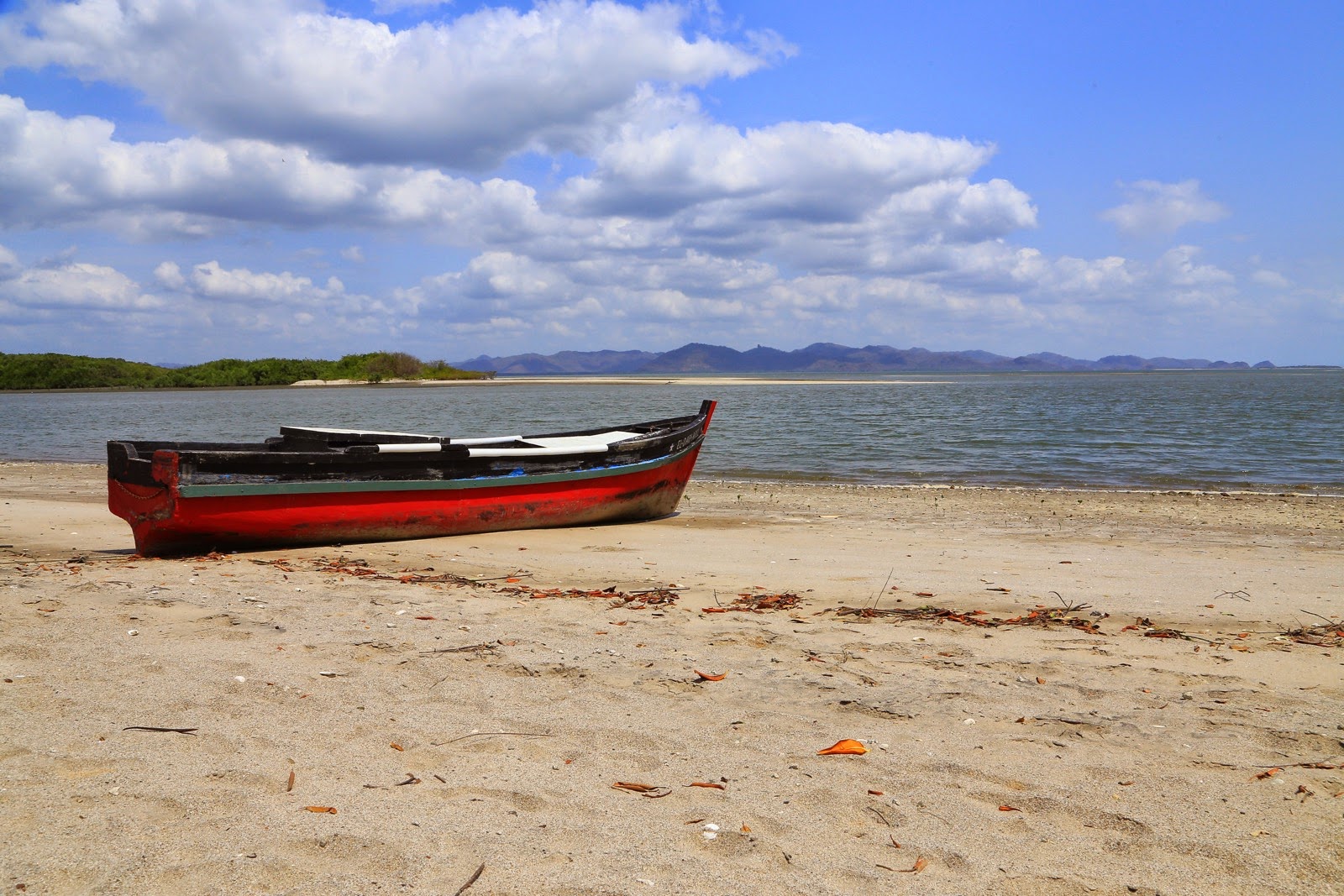 Barque rouge sur le sable blanc