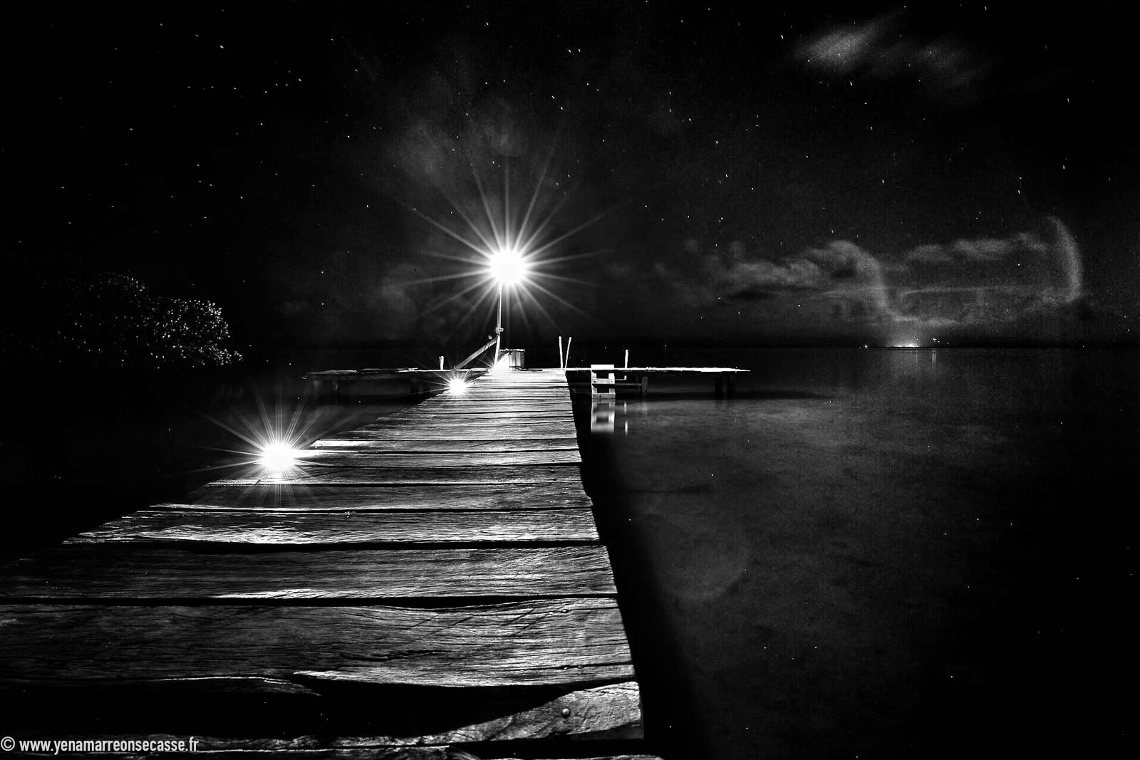 Ponton éclairé la nuit, en noir et blanc