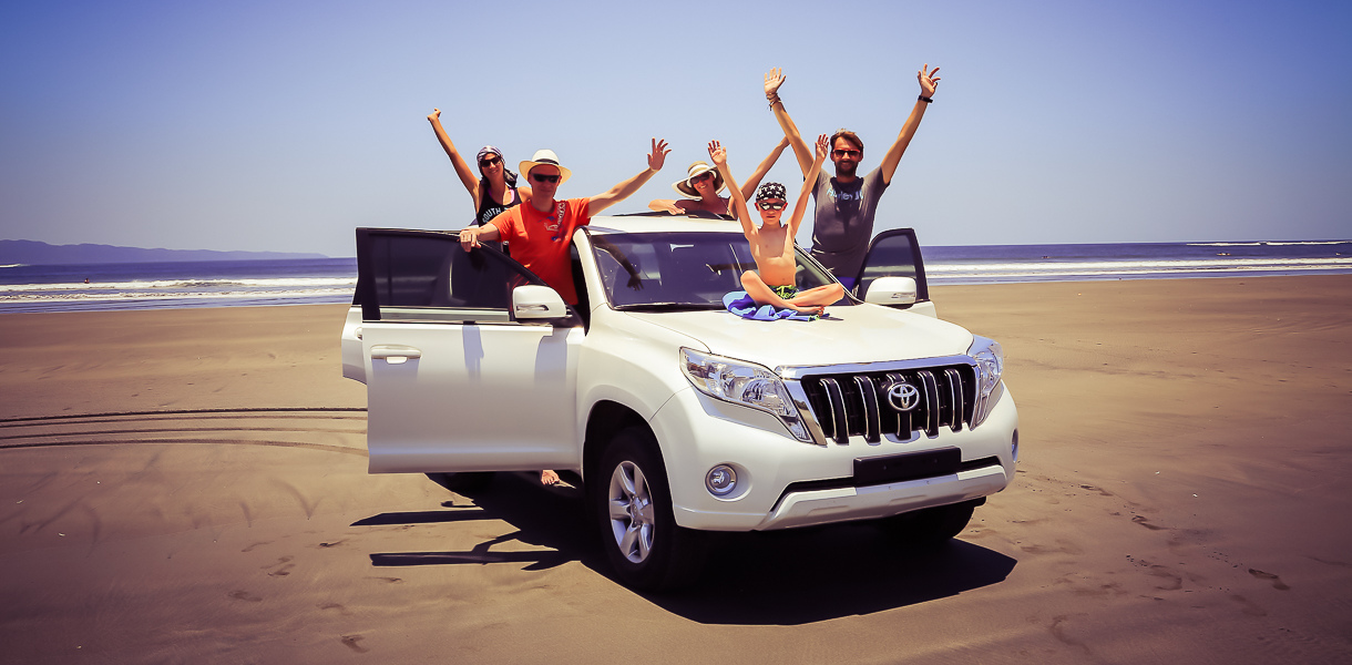 En famille sur un 4x4 garé sur la plage du Pacifique