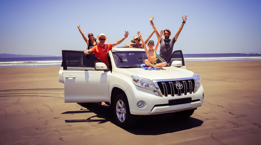 En famille sur un 4x4 garé sur la plage du Pacifique