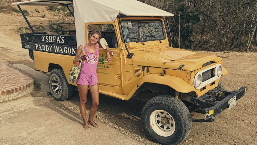 Adele en combishort rose devant un vieux Toyota Land Cruiser
