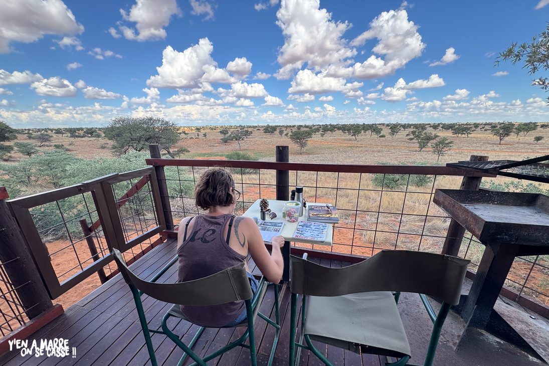 Terrasse en bois d’une cabane avec vue sur les dunes du Kalahari