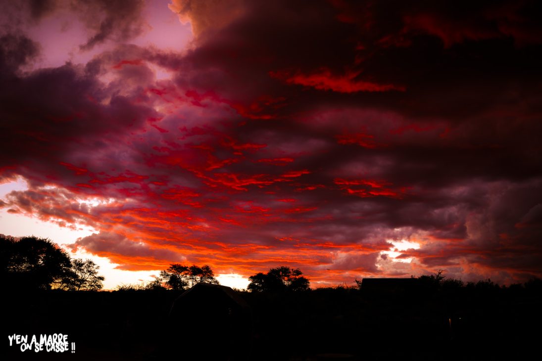 Ciel rouge flamboyant après un orage dans le désert du Kalahari