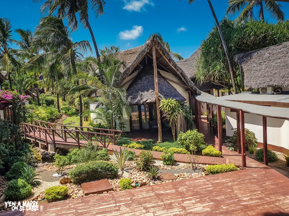 Bâtiment au toit de chaume au milieu du jardin tropical de l’hôtel